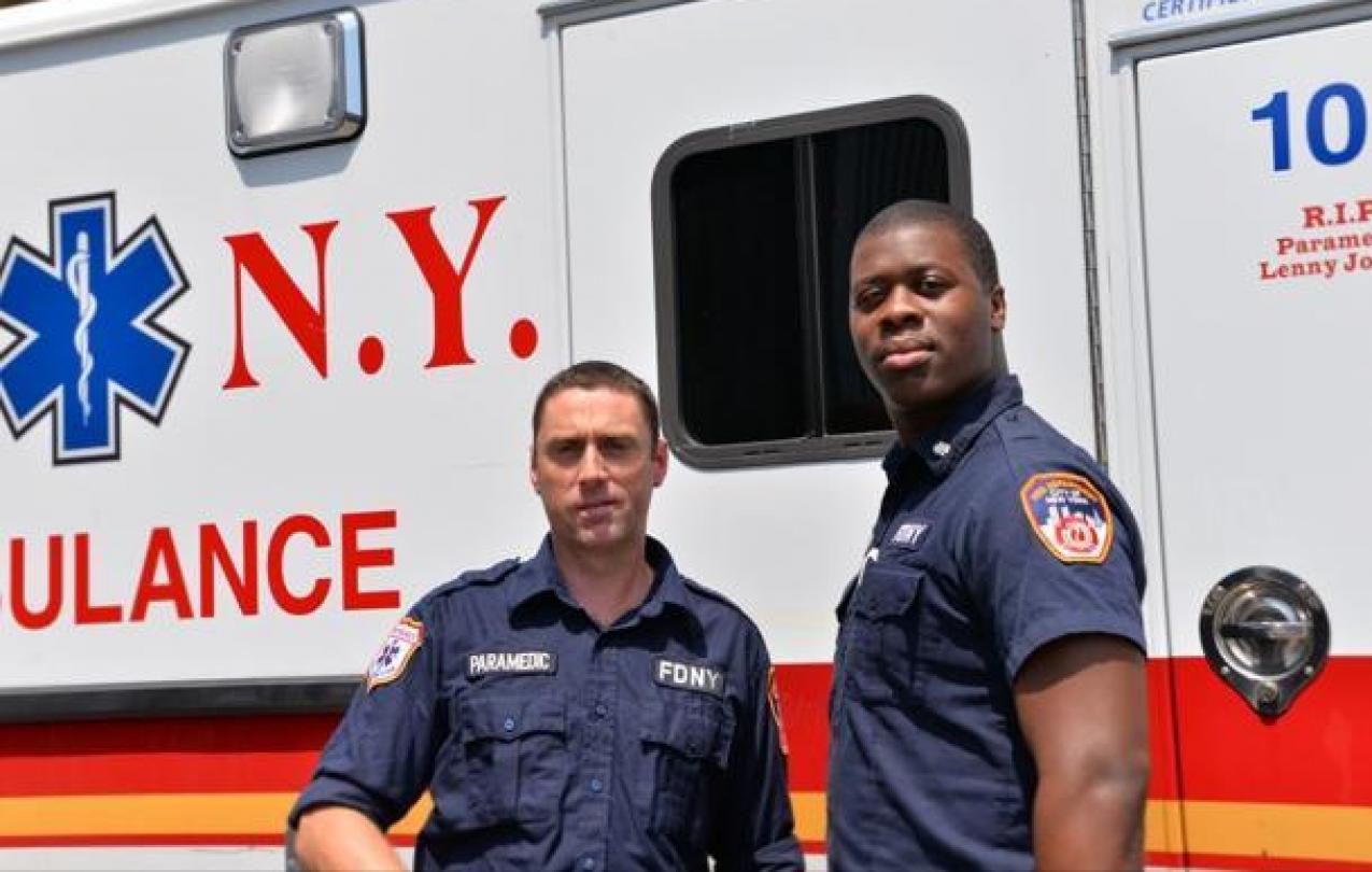 EMT Niall O’Shaughnessy, left, and his partner Moses Nelson stand by their emergency vehicle.