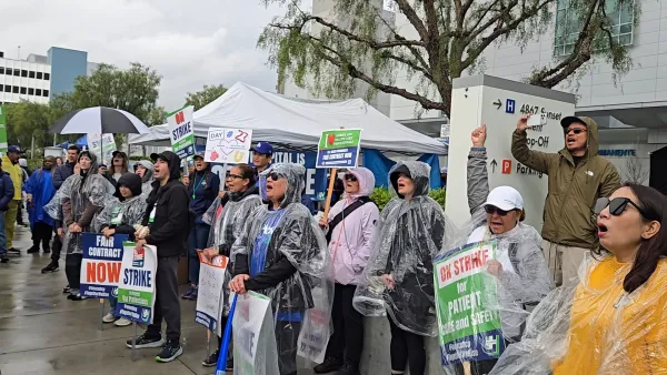 Nurses and health care professionals rally in the rain outside Kaiser Los Angeles Medical Center