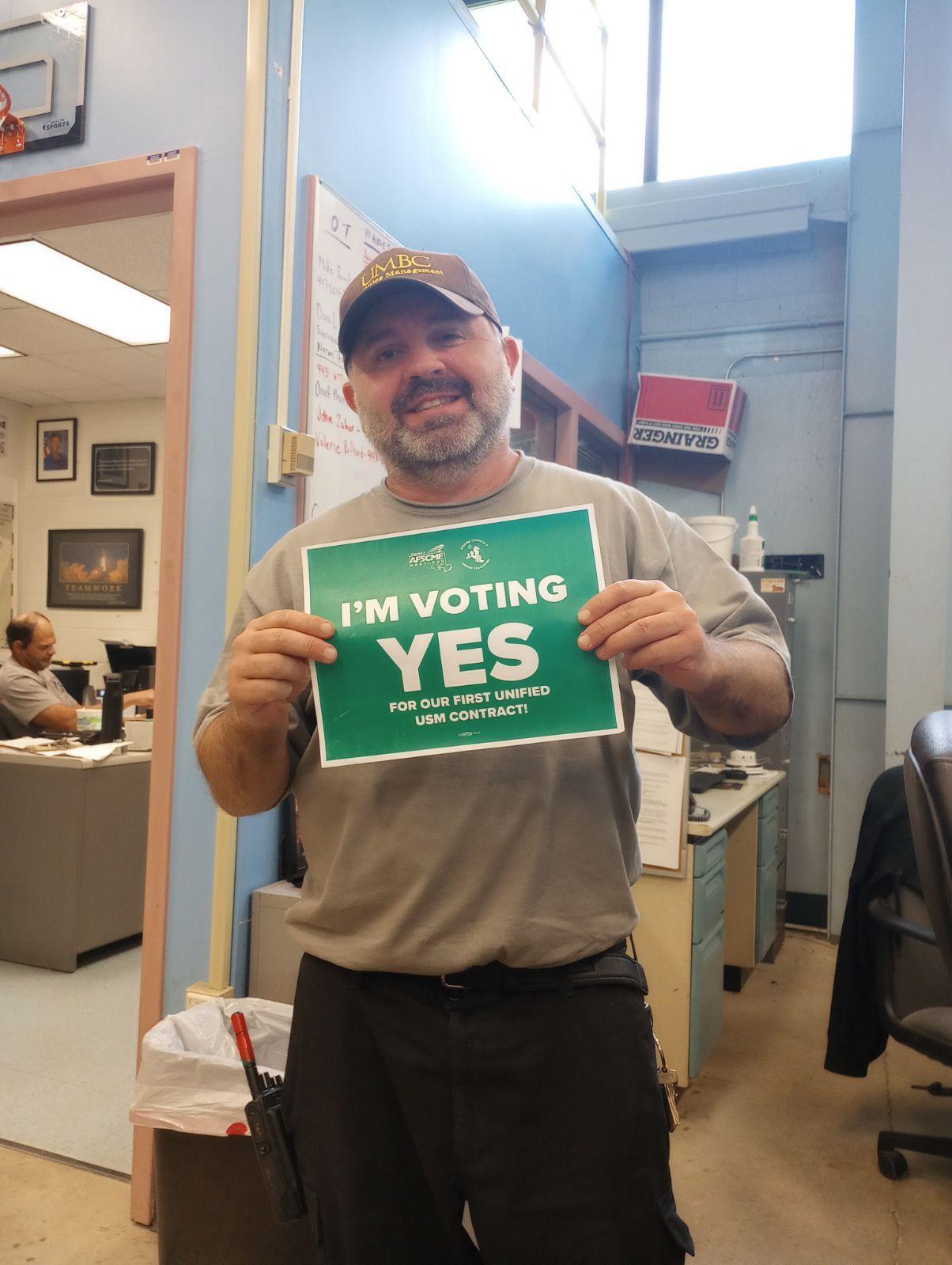 A photo of Cint Stevens holding an "I'm voting yes!" sign