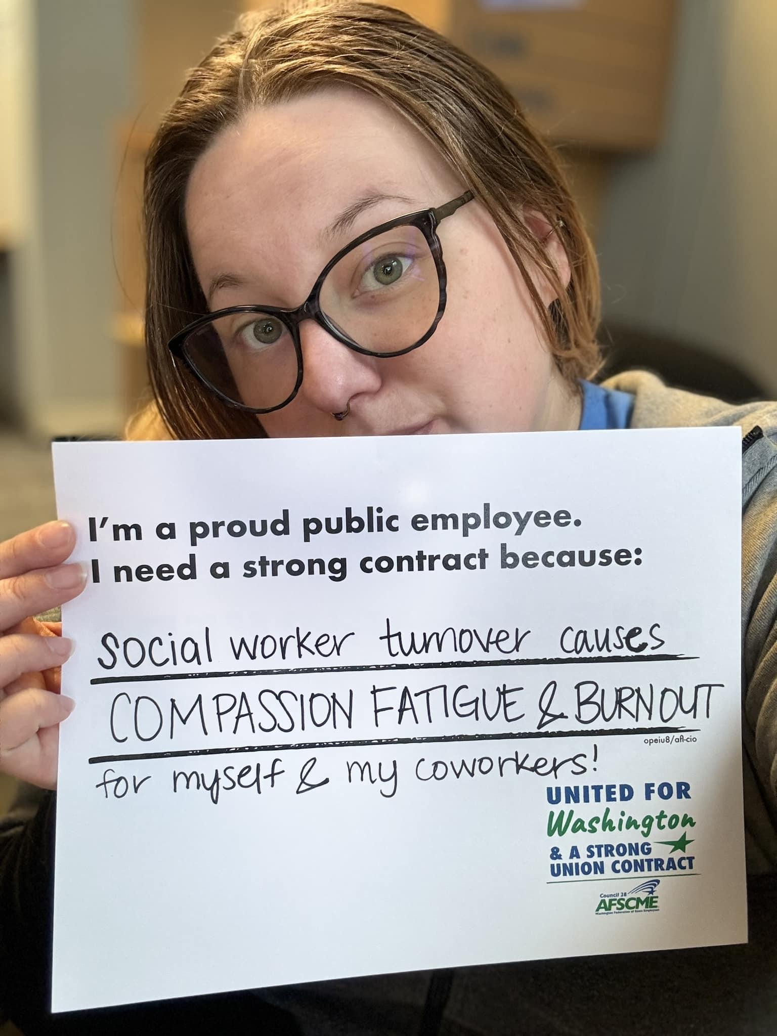 Jess, a DCYF member holding a sign that says "Social worker turnover causes compassion fatigue and burnout for myself and my coworkers.